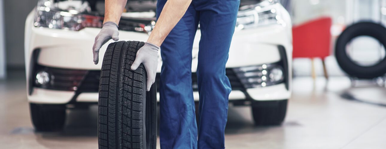Meccanico con uno pneumatico nuovo nell'autofficina a Cremona